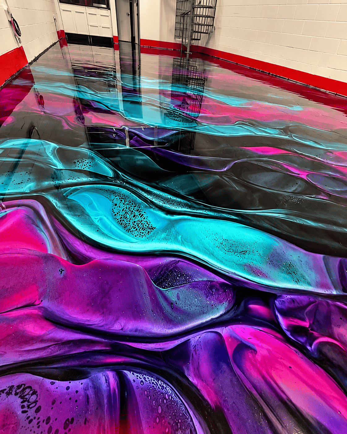 Colorful epoxy flooring with swirling patterns and glossy finish in a commercial space.