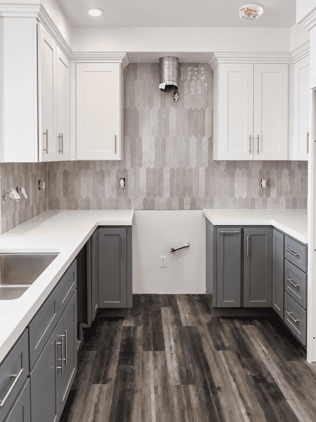 Contemporary kitchen with gray cabinets and dark wood flooring.