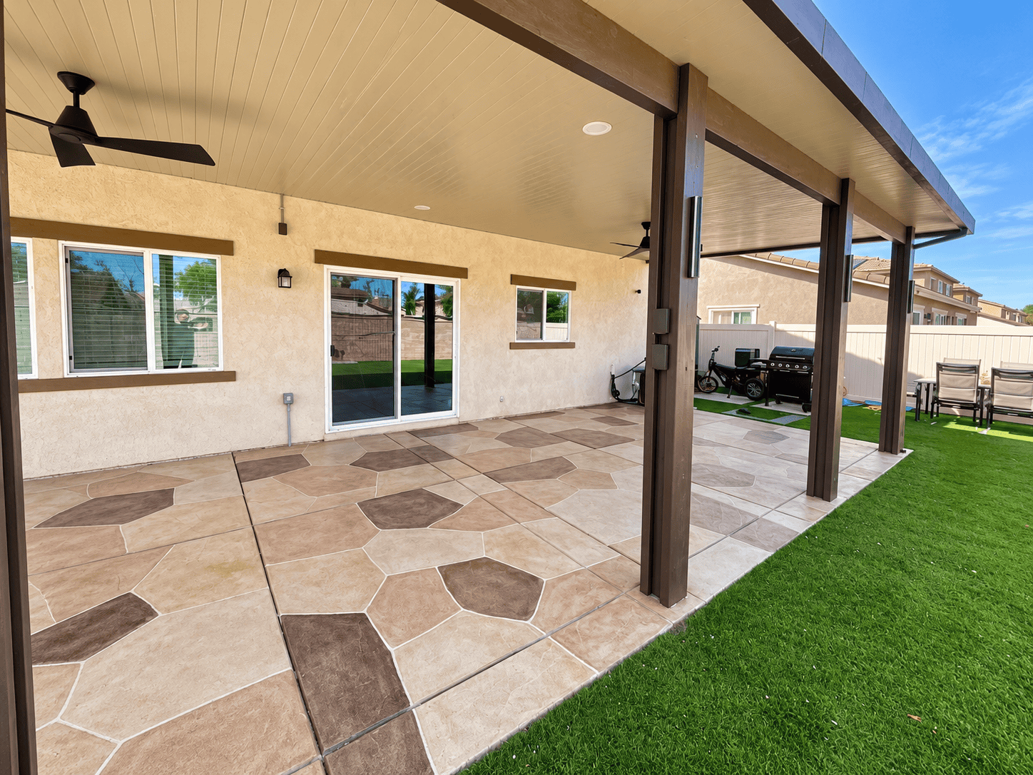 Beautiful tiled patio with covered area and outdoor furniture.