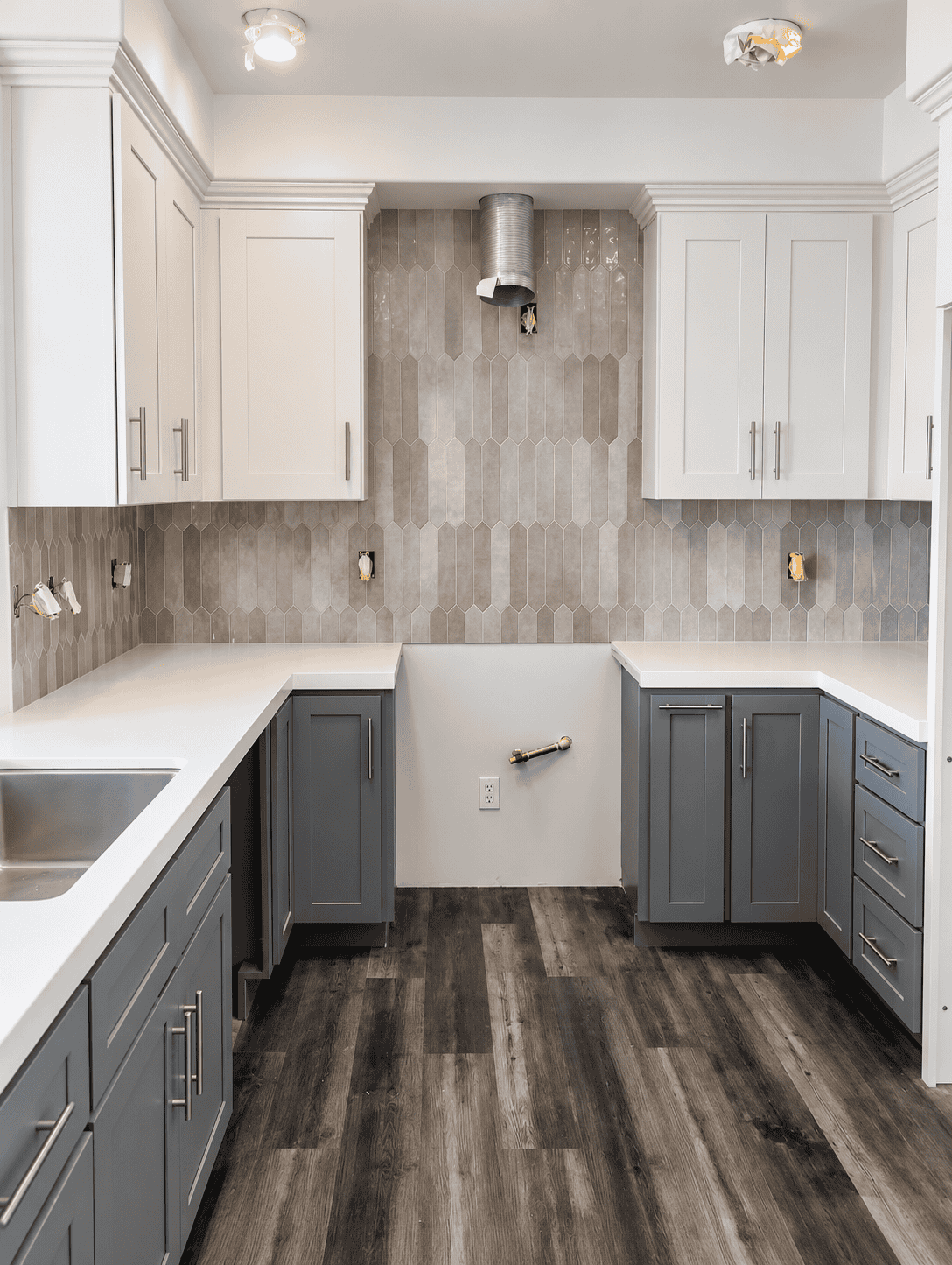 Contemporary kitchen with gray cabinets and dark wood flooring.