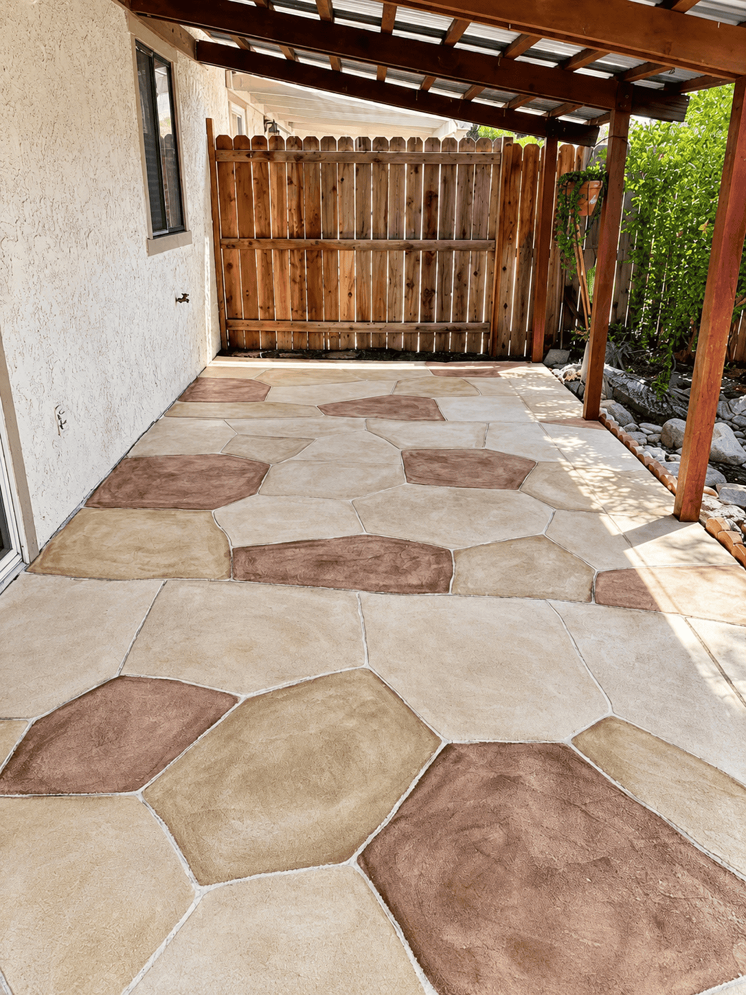 Beautiful outdoor patio with hexagonal carpet tiles and wooden fence.