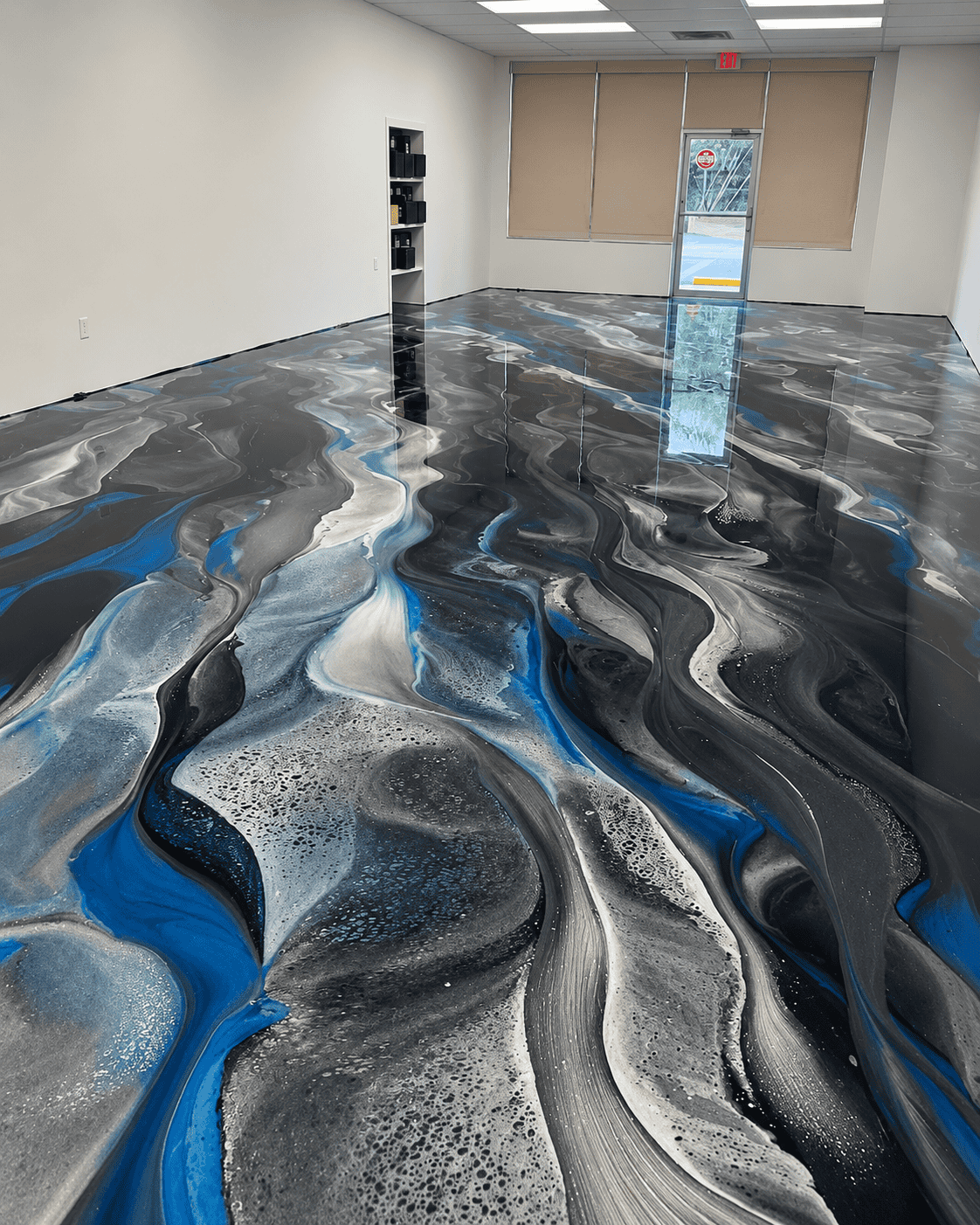 Beautiful epoxy floor with black, white, and blue swirls in commercial space.