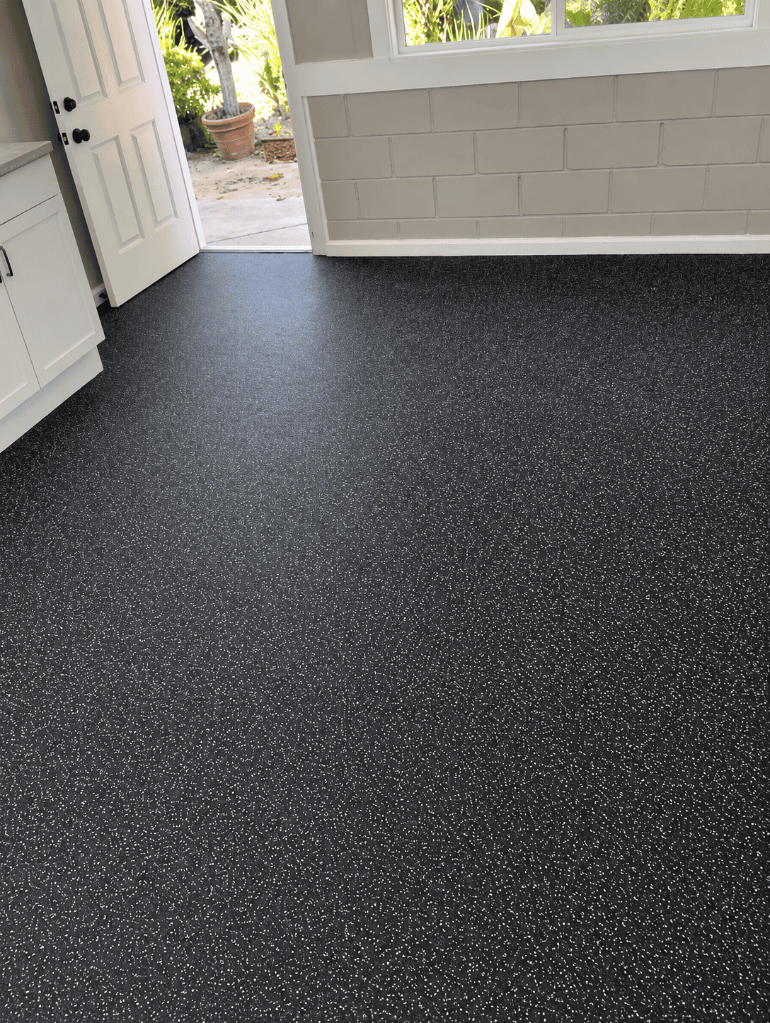 Interior view of a room with new black speckled carpet flooring.