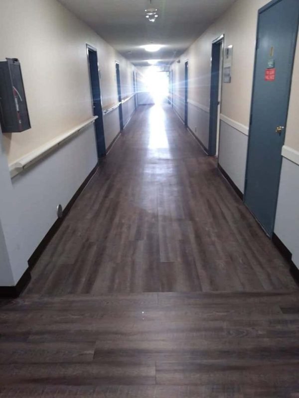 Smooth wood floor installation in hospital corridor, durable flooring solutions by Ramos Carpet Installation Inc.